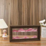 Shadow box with a miniature mountain landscape scene featuring pink and white peaks.