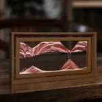 Optical illusion artwork of mountain peaks created with layered wood and paint, framed in a wooden box, showcasing a 3D mountain landscape illusion.