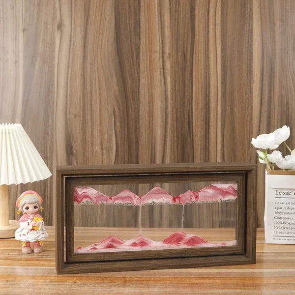 A miniature magnetic mountain landscape with pink peaks inside a wooden frame.