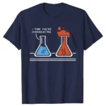 A humorous graphic T-shirt featuring two cartoon laboratory flasks with faces, one blue and one red, with the blue flask saying "I think you're overreacting" as the red flask bubbles over.