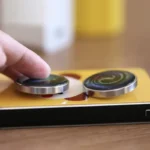 Close-up of a magnetic spin top toy being spun on a yellow surface, demonstrating magnetic levitation and motion.