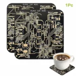 A black printed circuit board (PCB) with intricate gold pathways, designed for electronic DIY projects, accompanied by a cup of coffee on a matching PCB coaster.