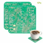Green printed circuit board coaster with intricate electronic design, paired with a cup of coffee on a matching circuit-themed coaster.