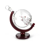 Decorative globe featuring a miniature ship inside a glass sphere, mounted on a wooden stand, ideal for science decor and educational displays.