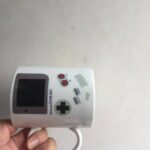 Vintage-inspired Game Boy-themed mug featuring classic gaming buttons and display.