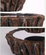 Close-up of a multi-tiered stone fountain with textured, natural stone surfaces and flowing water, ideal for garden decor and educational displays.