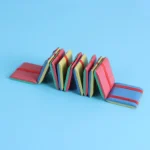 Foam dominoes arranged in a line, showcasing vibrant colors like red, yellow, blue, and green on a light blue background.