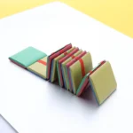 Miniature book stack puzzle with vibrant colors, designed as an educational toy for children to develop fine motor skills and cognitive abilities.