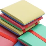 Brightly colored science notebooks and journals stacked, ideal for educational activities and science projects for children and students.