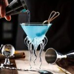 Colorful science cocktail in a glass with a unique, artistic stand, perfect for science-themed decor or educational demonstrations.