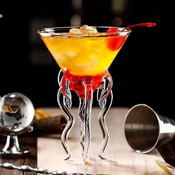 Elegant cocktail served in a glass with a unique tentacle-shaped stand, garnished with a cherry and ice cubes, perfect for science-themed decor or educational displays.