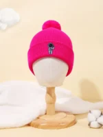 Bright pink baby beanie featuring a cute astronaut patch, perfect for keeping little ones warm and stylish during cold weather. Made from soft, cozy material ideal for infants and toddlers.