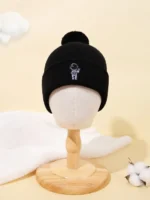 Black beanie hat with a small embroidered astronaut patch on the front.