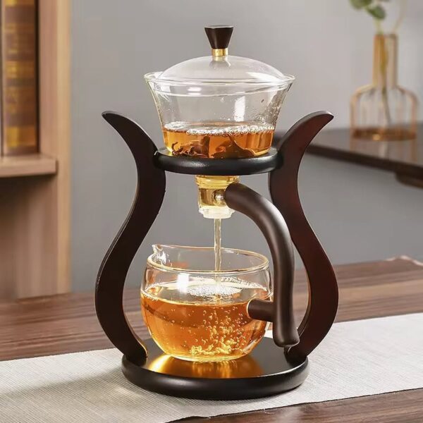 Elegant glass teapot with infuser and wooden stand, perfect for brewing and serving tea with a modern, stylish design.