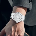 A sleek, modern silver watch with a minimalist design worn on a man's wrist, showcasing contemporary style and precision craftsmanship.