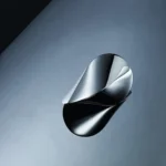 Abstract metallic sculpture with sleek curves and reflective surface, displayed against a neutral background.