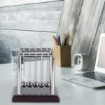 Classic Newton's Cradle desktop science toy with metal balls demonstrating conservation of momentum and energy. Perfect for educational and office decor.