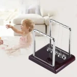 Child playing with Newton's Cradle science toy, demonstrating physics principles in a bright, modern living room.