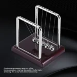 Classic Newton's Cradle with metal balls demonstrating physics principles, perfect for science decor and educational purposes.