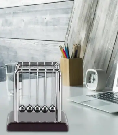 Classic Newton's Cradle desktop science toy with metal balls demonstrating conservation of momentum and energy. Perfect for educational and office decor.