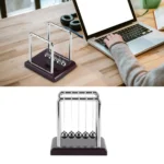 Classic Newton's Cradle with metal balls on a wooden base, used for demonstrating momentum and energy transfer in physics experiments.