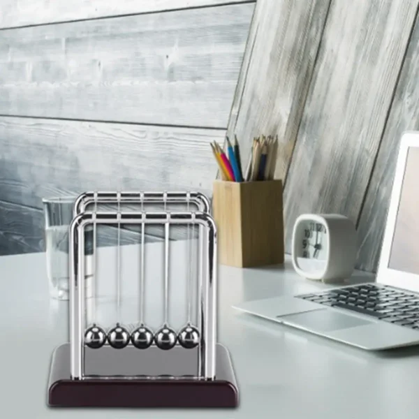 Classic Newton's Cradle desktop science toy with metal balls demonstrating conservation of momentum and energy. Perfect for educational and office decor.