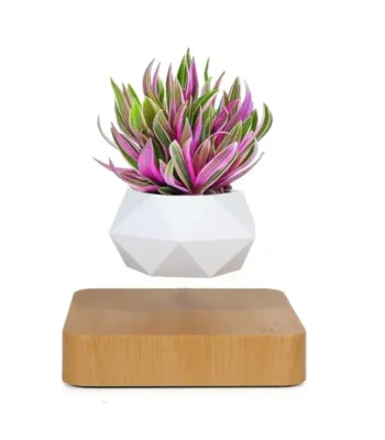 Decorative geometric white planter with vibrant pink and green plants, displayed on a wooden base for a stylish and contemporary look.