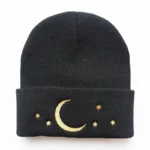 Black knit beanie featuring embroidered crescent moon and stars, perfect for cozy winter wear and celestial-themed fashion.