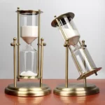 Elegant sand timer with brass frame and glass bulbs, ideal for educational decor and science displays.