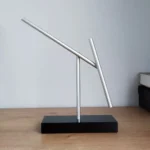 Innovative magnetic balance sculpture demonstrating physics principles with sleek metal rods on a black base. Perfect for educational displays and science enthusiasts.