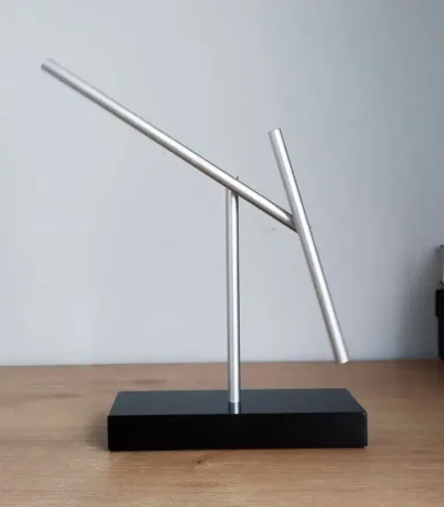 Innovative magnetic balance sculpture demonstrating physics principles with sleek metal rods on a black base. Perfect for educational displays and science enthusiasts.