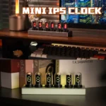 Mini IPS Clock with colorful Nixie tube display on a desk setup.