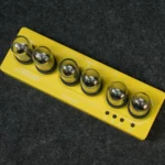 A yellow magnetic ball puzzle toy with six shiny metal balls arranged in a row on a yellow base, designed for educational and entertainment purposes.