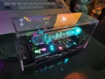 Digital science clock with colorful LED lights inside a transparent case, displaying time and temperature.