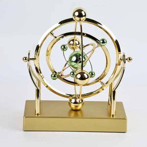 Atomic model desk decor with gold and green spheres representing electrons and nucleus, mounted on a rectangular gold base. Perfect for science enthusiasts and educational settings.