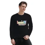 A young man wearing a black sweater featuring a colorful periodic table design, standing against a white background.