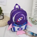 Colorful space-themed children's backpack featuring a rocket ship design with pink wings and a starry galaxy background. Perfect for school, travel, or as a fun decor piece.