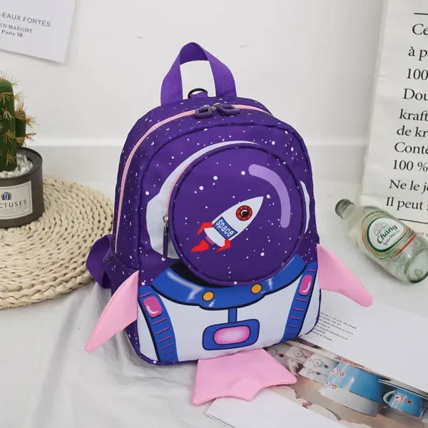 Colorful space-themed children's backpack featuring a rocket ship design with pink wings and a starry galaxy background. Perfect for school, travel, or as a fun decor piece.