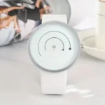 Modern minimalist white watch featuring a circular dial with black accents and a sleek design, perfect for contemporary fashion and everyday wear.