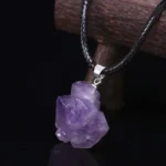 Amethyst crystal pendant necklace on black cord with silver bail, showcasing a raw purple gemstone.