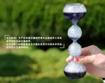 Hand holding a glass water balancing toy with three glass spheres, demonstrating a fun science experiment for educational and decorative purposes.