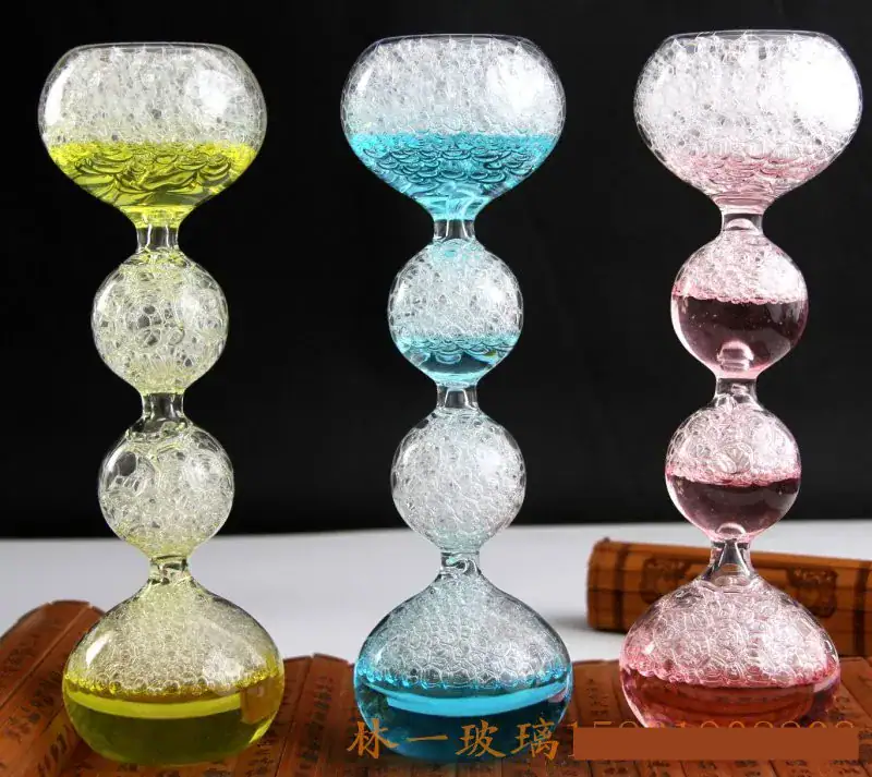 Colorful glass hourglasses with bubbling liquid in yellow, blue, and pink. Vibrant glass hourglasses filled with bubbling colored liquids in yellow, blue, and pink, displayed against a black background.