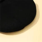 Black round object, possibly a speaker or scientific equipment component.