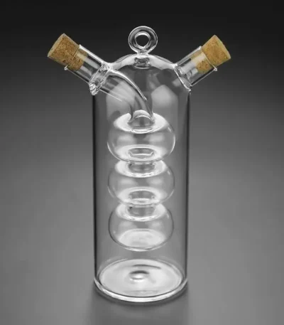 Glass spiral distillation apparatus with cork stoppers, used for chemistry experiments.