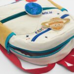 Children's backpack featuring space-themed and animal patches, with colorful zippers and a playful design, ideal for school and educational activities.