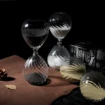 Elegant set of hourglass-shaped glassware with black and white swirling patterns, ideal for science experiments, educational demonstrations, or stylish home decor.
