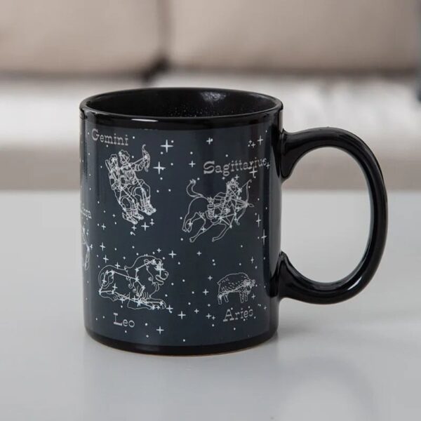 Black ceramic mug featuring white zodiac constellation illustrations of Gemini, Sagittarius, Leo, and Aries with their names, set against a starry background.