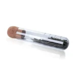 Small glass test tube with cork stopper containing dried herbs or plant material, ideal for educational science experiments and decorative displays.