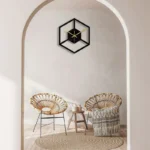 Stylish geometric wall clock featuring a black hexagon frame with gold clock hands, perfect for contemporary home decor.