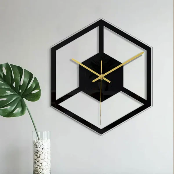 Stylish black and gold geometric wall clock with a 3D cube design, mounted on a white wall, adding a contemporary touch to home decor.
